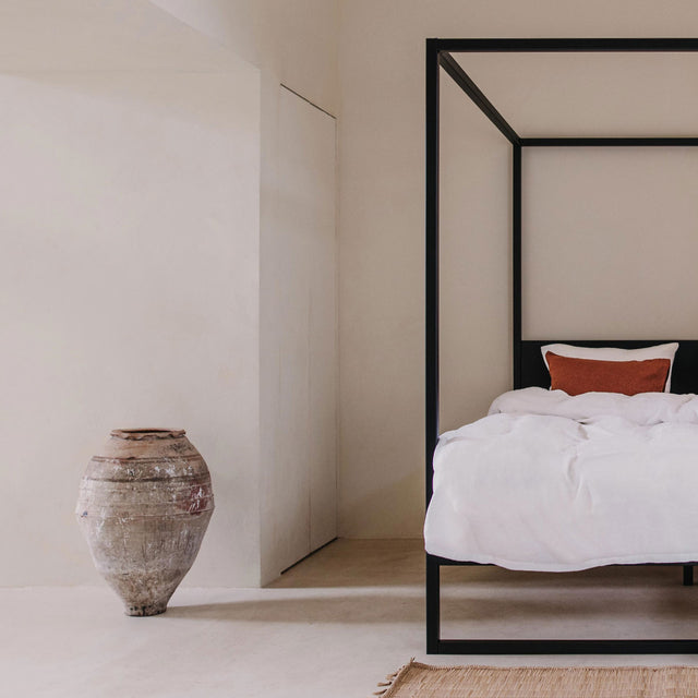 Bed metalen frame zwart hemelbed van Robuust Amsterdam in ruimte met vaas