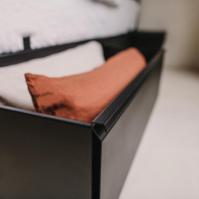 Lades zwarte metalen bedframe met kussens van Robuust Amsterdam