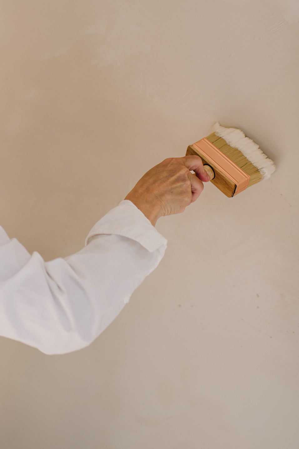Aanbrengen met kwast van de We Are Wow Makers x Robuust verf op muur.