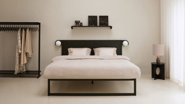 Duurzaam Matras °01 van Robuust Amsterdam op een metalen zwart stalen bedframe in een slaapkamer