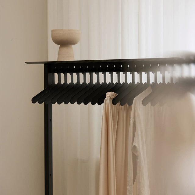 Duurzaam interieur van Robuust Amsterdam een Wardrobe met hangers in het zwart met witte shirts aan hangers